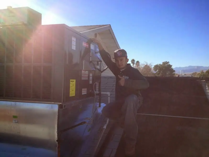 HVAC technician performing AC Tune-Up on a rooftop unit in Rossmoor