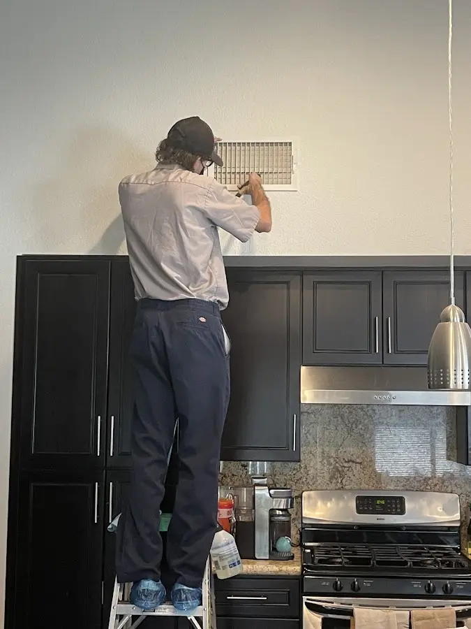 Technician inspecting an air vent during HVAC service in Rossmoor